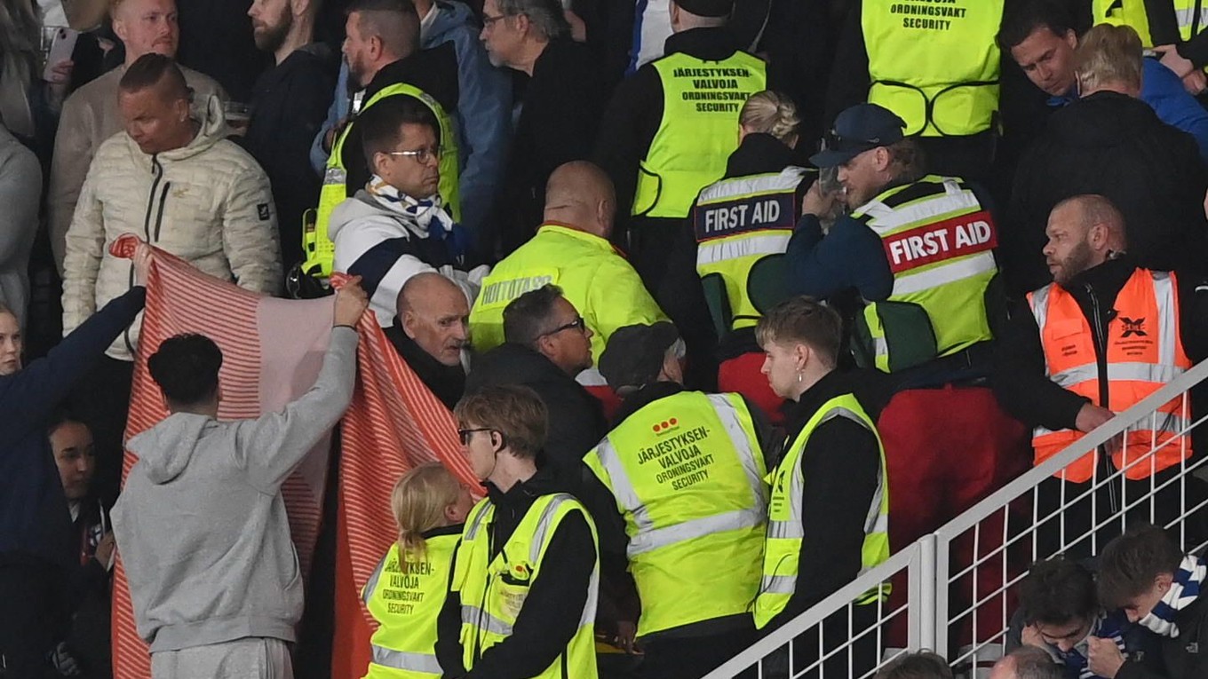 Záchranári poskytujú prvú pomoc fínskemu fanúšikovi, ktorý skolaboval počas zápasu Fínsko – Poľsko.