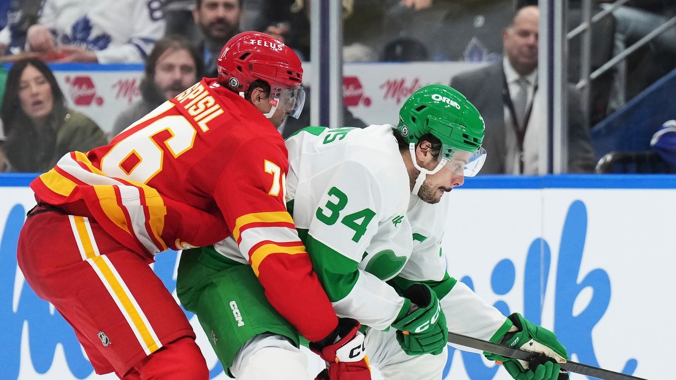 Martin Pospíšil (Calgary) sa snaží odstaviť od puku Austona Matthewsa (Toronto).