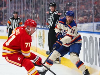Hráč Edmontonu Oilers Mattias Ekholm (vpravo) strieľa cez Slováka Šimona Nemca z Calgary Flames v zápase zámorskej hokejovej NHL.