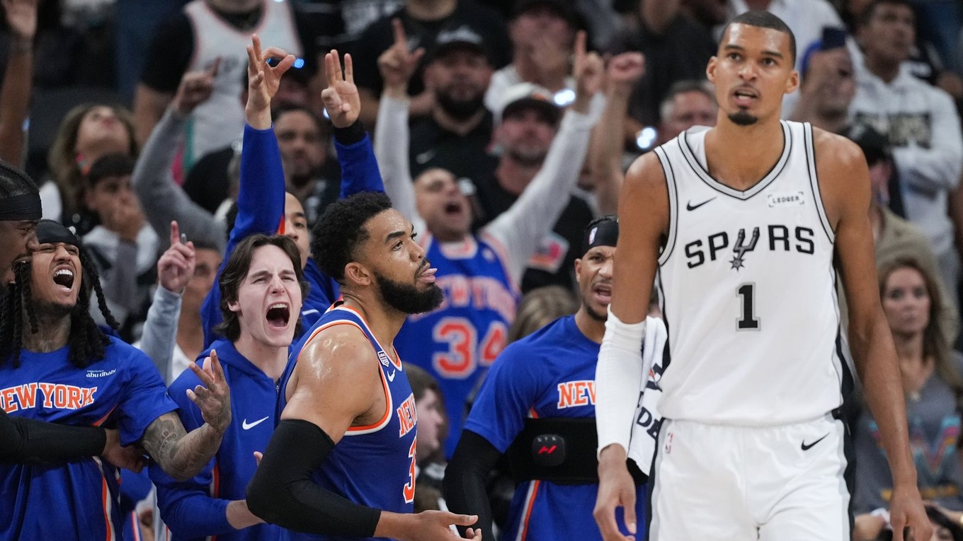 Hráči New York Knicks oslavujú koš, zatiaľ čo útočník San Antonio Spurs Victor Wembanyama (1) odchádza