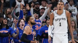 Hráči New York Knicks oslavujú koš, zatiaľ čo útočník San Antonio Spurs Victor Wembanyama (1) odchádza