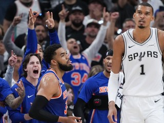 Hráči New York Knicks oslavujú koš, zatiaľ čo útočník San Antonio Spurs Victor Wembanyama (1) odchádza