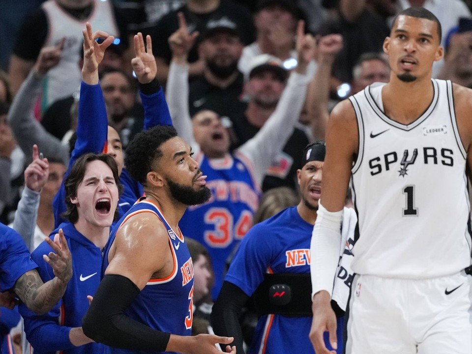 Hráči New York Knicks oslavujú koš, zatiaľ čo útočník San Antonio Spurs Victor Wembanyama (1) odchádza