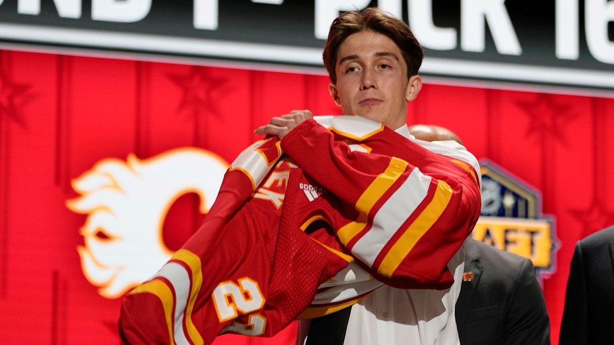 Samuel Honzek si oblieka dres Calgary Flames vo vstupnom drafte NHL 2023. 