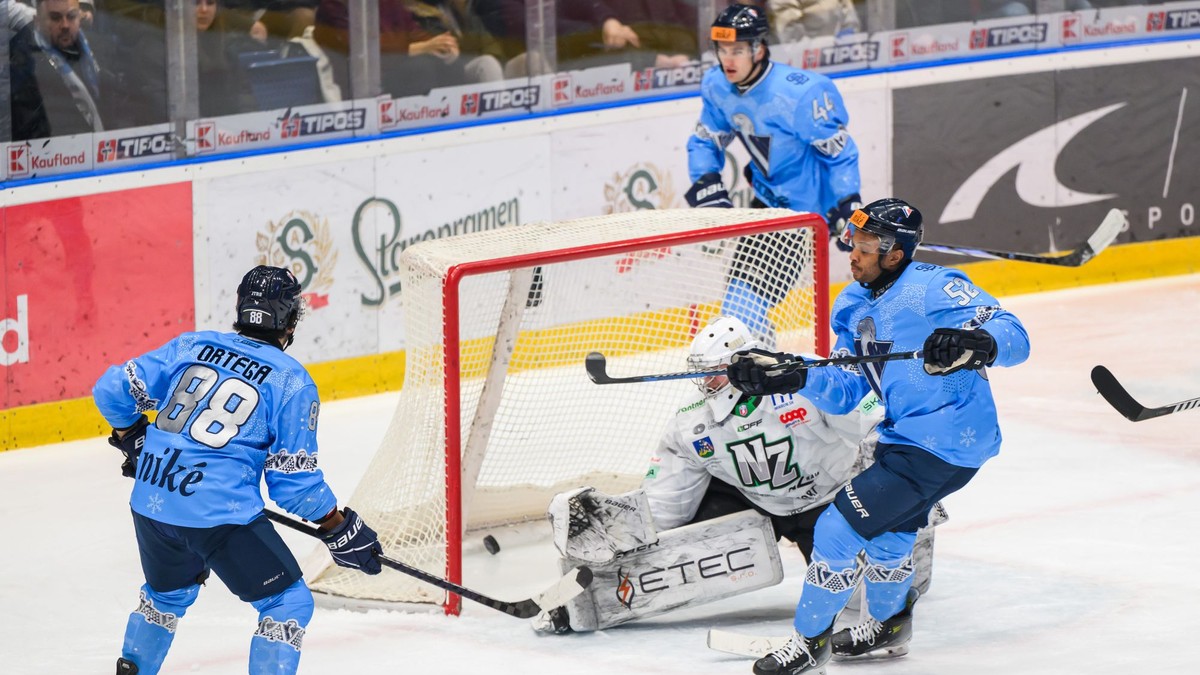 Zľava Austin Ryan Ortega (Slovan), Roman Rychlík (Nové Zámky) a Sena Wendell Acolatse (Slovan) počas gólu počas 33. kola Tipos extraligy HC Slovan Bratislava - HC Nové Zámky.