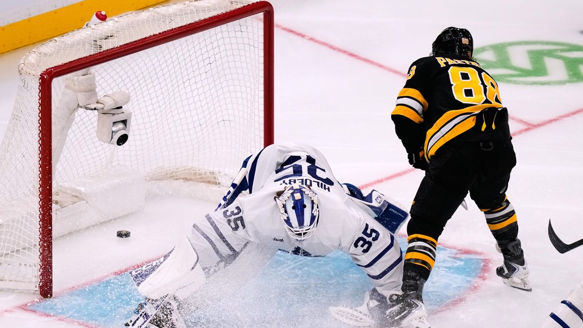 Na snímke brankár Toronta Maple Leafs Dennis Hildeby, ktoré prekonáva hokejista Bostonu Bruins David Pastrňák a strelia svoj 400. gól v kariére.