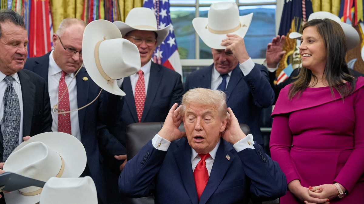 Americký prezident Donald Trump (uprostred) si upravuje vlasy počas spoločného fotenia sa s členmi tímu amerických hokejistov, ktorí na ZOH 1980 v Lake Placid senzačne získali zlaté medaily.