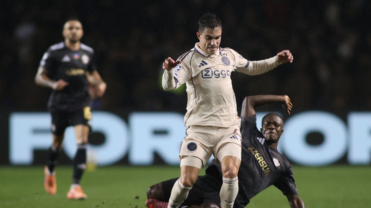 Hráč Ajaxu Lucas Rosa a hráč Qarabagu Emmanuel Addai bojujú o loptu počas zápasu.