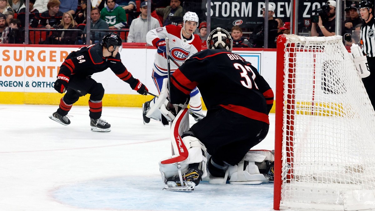 Hráč Montrealu Canadiens Juraj Slafkovský (20) strieľa gól, keď prekonáva brankára Caroliny Hurricanes Brandona Bussiho (32).