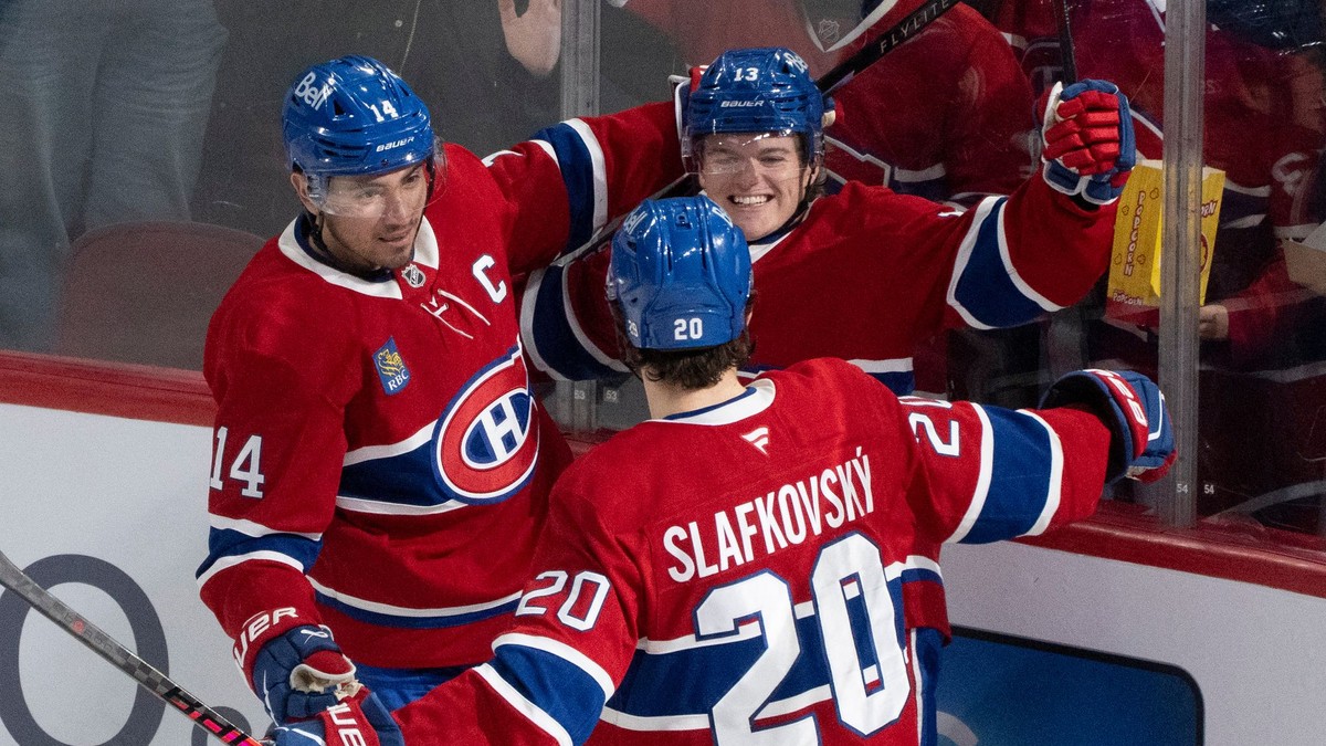 Slovenský hokejista v drese Montrealu Juraj Slafkovský (20) a jeho spoluhráč Nick Suzuki (14) sa tešia z gólu, ktorý strelil Cole Caufield (13).