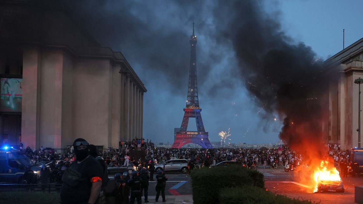Auto horí a ohňostroj exploduje po tom, čo fanúšikovia Paríža St. Germain oslavujú obhajobu titulu pred Eiffelovou vežou v Paríži po finálovom dueli Ligy majstrov.