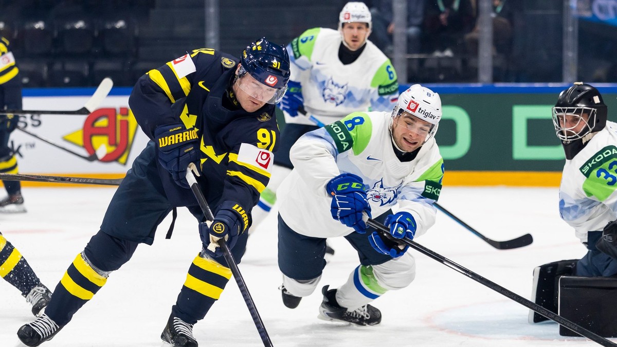 Na snímke Carl Grundström (vľavo) zo Švédska a Marcel Mahkovec (druhý sprava) bojujú o puk.