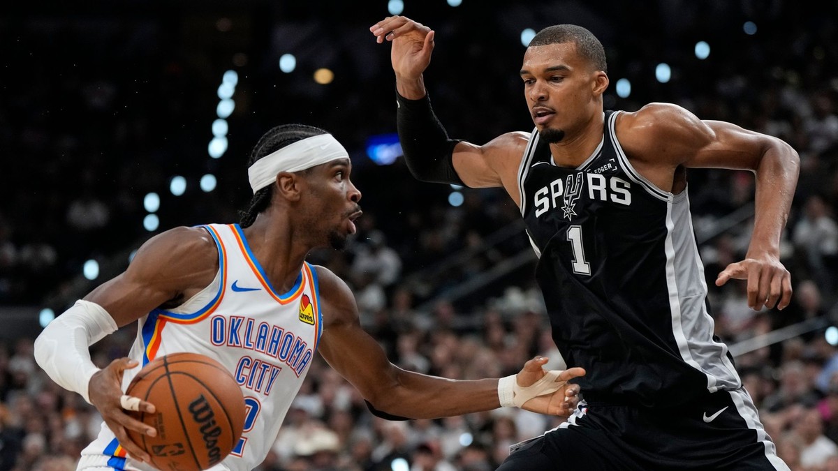 Rozohrávač tímu Oklahoma City Thunder Shai Gilgeous-Alexander (2) preniká popri krídelníkovi tímu San Antonio Spurs Victorovi Wembanyamovi (1).