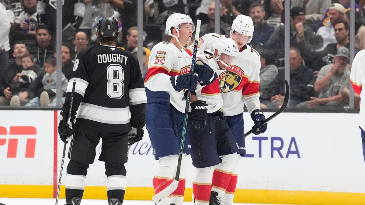 Ľavé krídlo tímu Florida Panthers Brad Marchand (druhý sprava) je po zranení odprevádzaný z ľadu ľavým krídelníkom Bradym Tkachukom (druhý zľava) a obrancom Nikom Mikkolom.