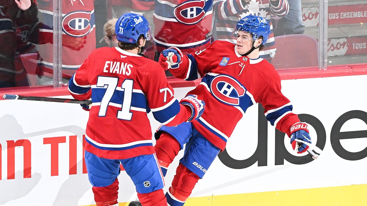 Hokejista Montrealu Canadiens Jake Evans (71) sa teší z víťazného gólu, ktorý strelil jeho spoluhráč Cole Caufield (13).