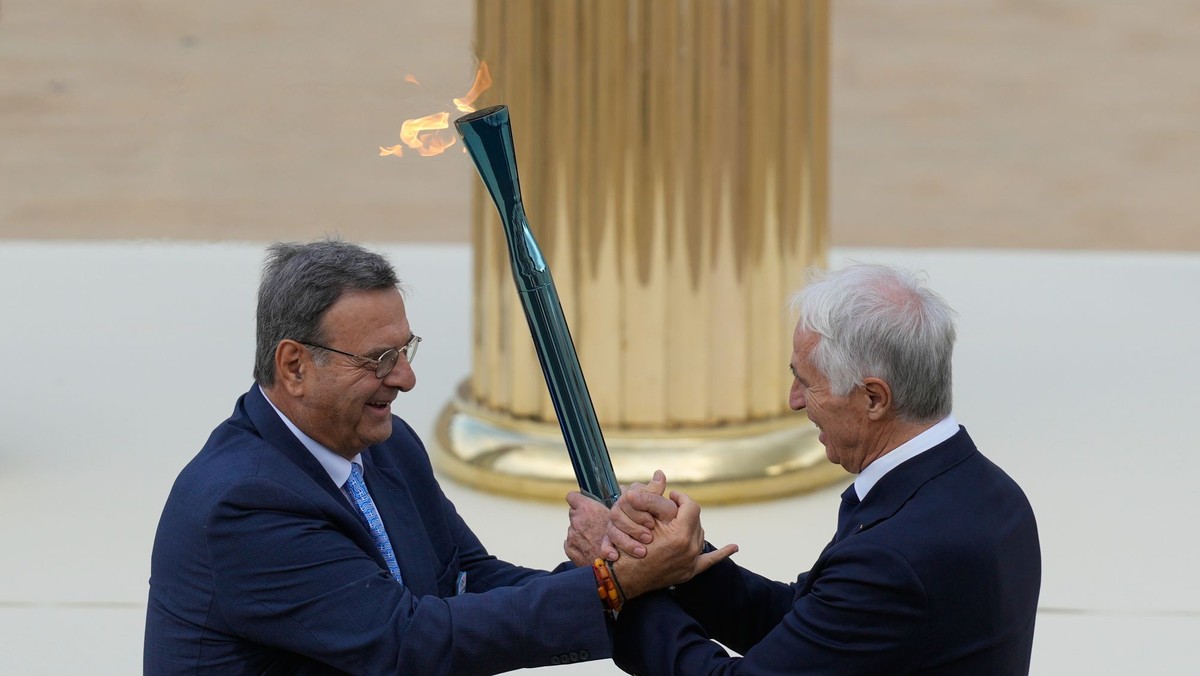 Isidoros Kouvelos (vľavo) odovzdáva pochodeň prezidentovi organizačného výboru Giovannimu Malagovi.