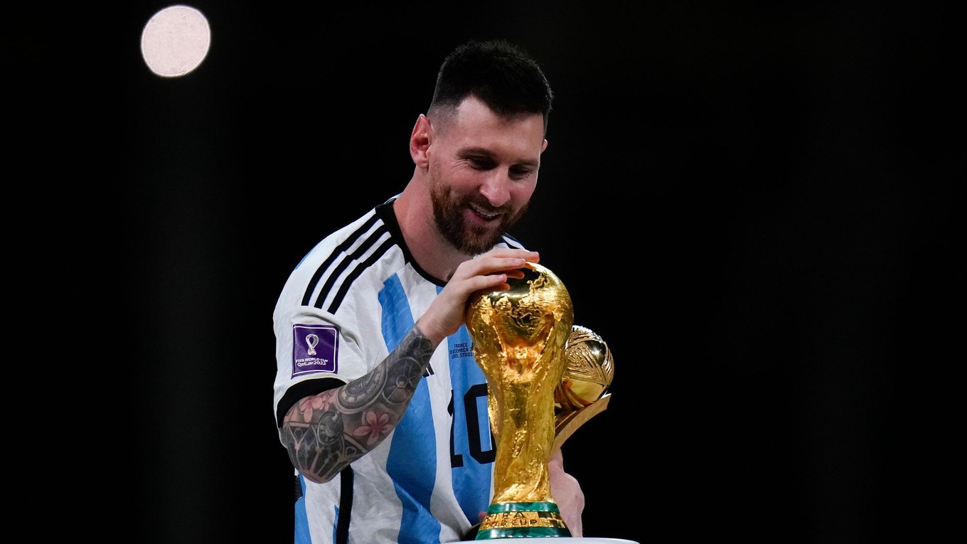 Lionel Messi sa dotýka trofeje pre víťazov MS vo futbale v Katare 2022.