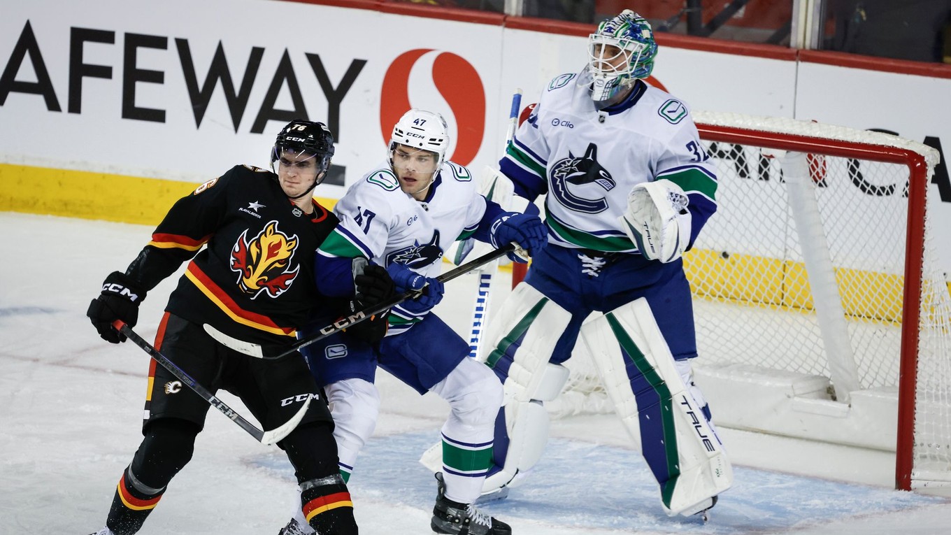 Zľava Martin Pospíšil, Noah Juulsen a brankár Kevin Lankinen v zápase NHL Vancouver Canucks - Calgary Flames.