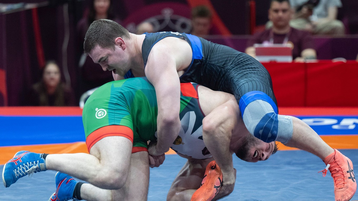 Maďarský zápasník Vladislav Bajcajev (dole) a Dzianis Chramiankov, štartujúci s neutrálnym štatútom pod hlavičkou UWW, bojujú v zápase o 3. miesto.