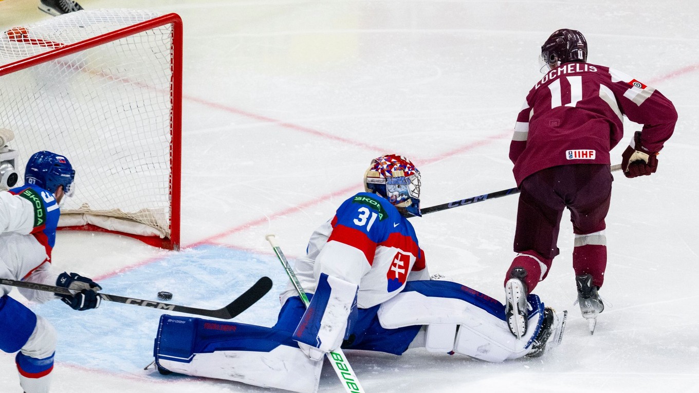 Dans Ločmelis strieľa gól brankárovi Samuelovi Hlavajovi v zápase Slovensko - Lotyšsko v skupine A na MS v hokeji 2025.