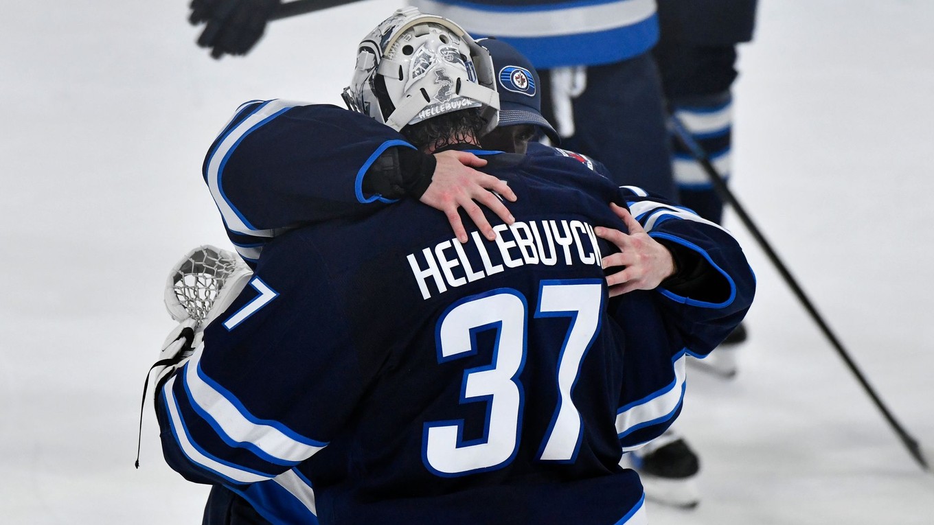 Brankári Winnipegu Eric Comrie (vľavo) a Connor Hellebuyck sa objímajú po výhre v rozhodujúcom siedmom zápase.