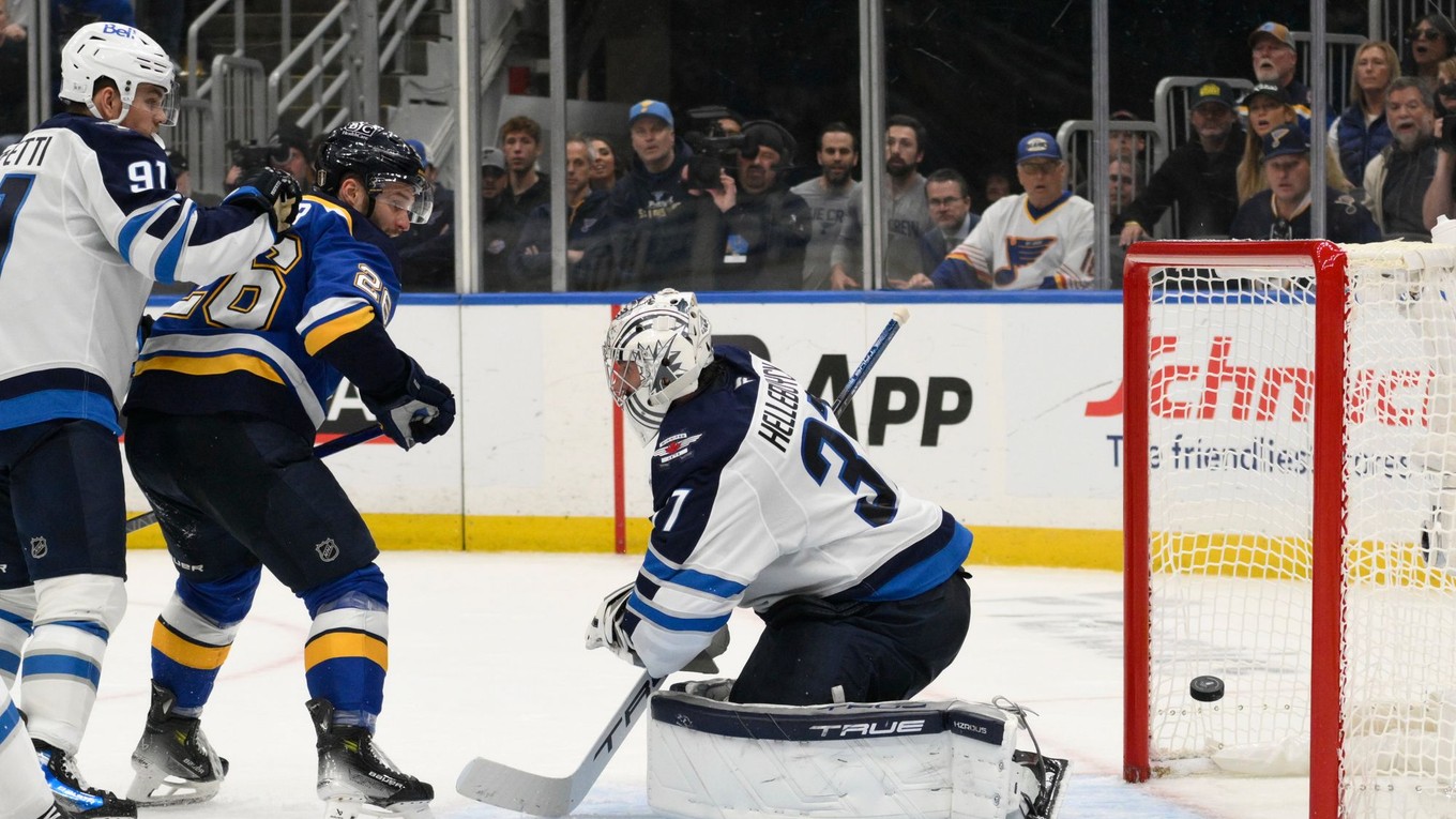 Brankár Connor Hellebuyck inkasuje po tom, čo sa presadil Nathan Walker v zápase St. Louis Blues - Winnipeg Jets v 6. dueli 1. kola play-off NHL.