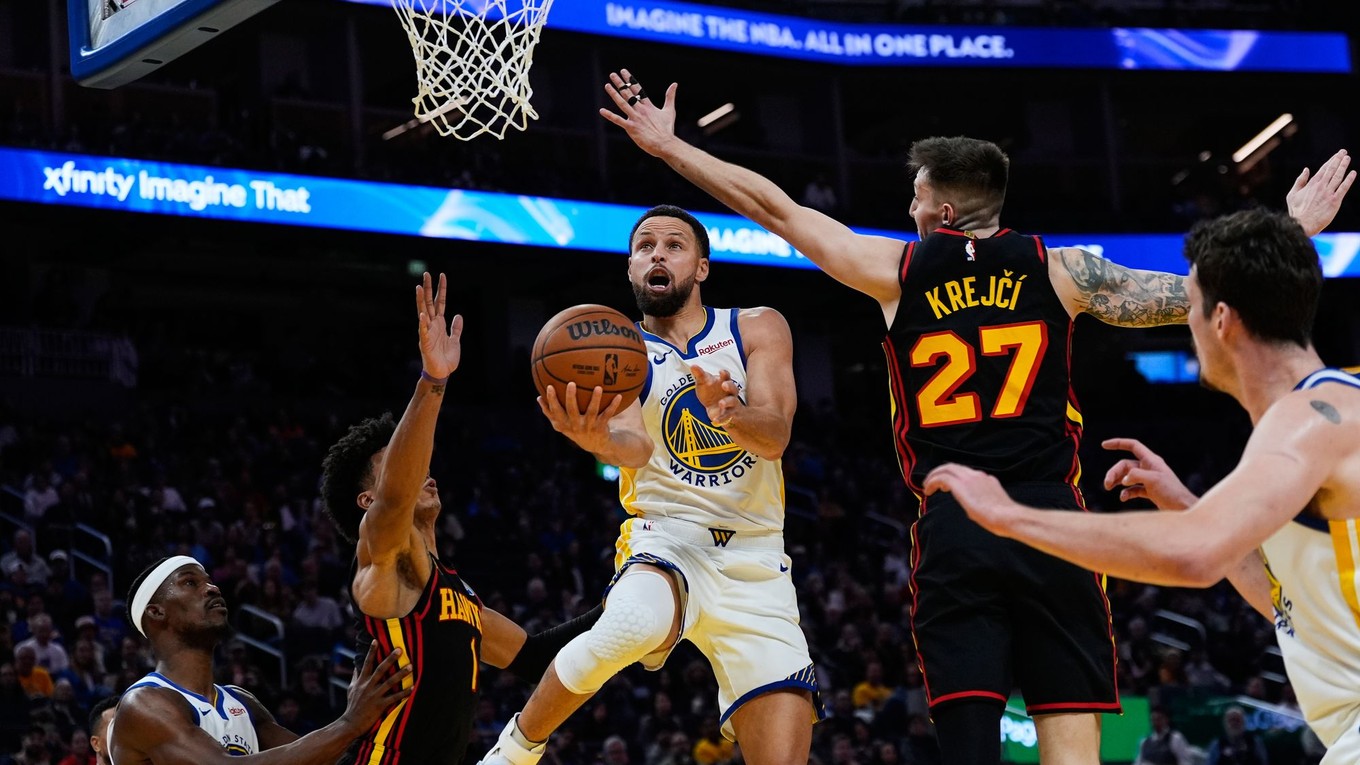 Rozohrávač Golden State Warriors Stephen Curry (30) strieľa medzi krídelníkom Atlanty Johnsonom (1) a rozohrávačom Krejčím (27).