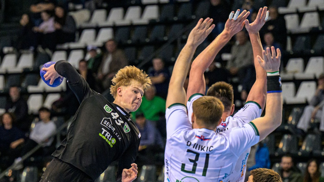 Vľavo Samuel Valent (Nové Zámky) strieľa cez hráčov Prešova počas zápasu 4. kola nadstavbovej časti Niké handball extraligy Tatran Prešov - MHC ŠTART Nové Zámky.