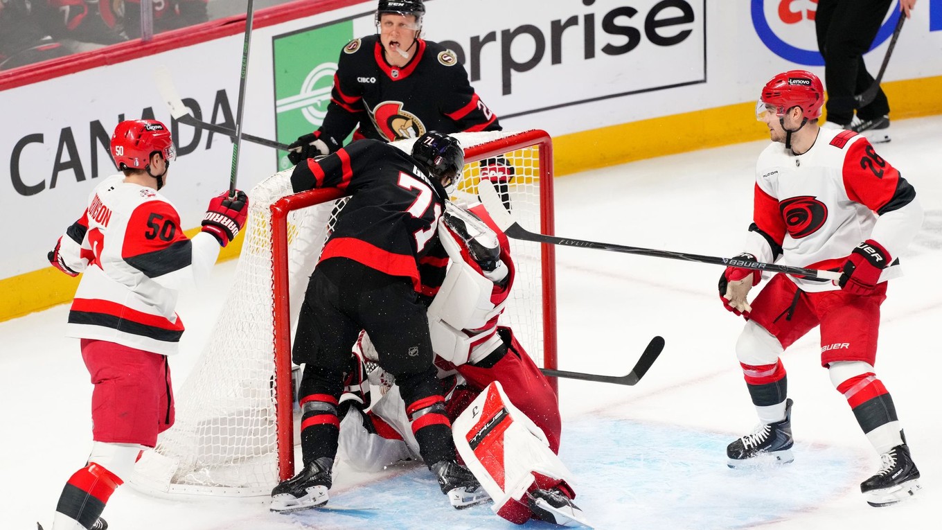 Center tímu Ottawa Senators Ridly Greig (71) narazil brankára tímu Carolina Hurricanes Frederika Andersena (vpravo v strede) do jeho brány.