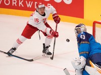 Andrej Šutov pri streleckom pokuse Patryka Wronku v zápase Kazachstan - Poľsko na MS v hokeji 2024.