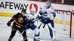 Zľava Martin Pospíšil, Noah Juulsen a brankár Kevin Lankinen v zápase NHL Vancouver Canucks - Calgary Flames.