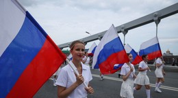 Účastníci nesú ruské štátne vlajky.