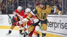 Slovenský hokejista v drese Calgary Flames Samuel Honzek (uprostred) a hráč Vegasu Jeremy Lauzon (vpravo) bojujú o puk.