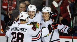 Hokejisti Chicago Blackhawks oslavujú gól v sieti Calgary Flames.