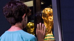 Mladý chlapec pozerá na trofej pre víťaza MS.