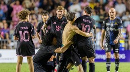 Fanúšik, ktorý sa dostal na ihrisko, chytá hráča Lionela Messiho z Interu Miami na konci prípravného futbalového zápasu.