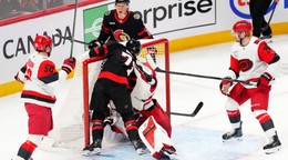 Center tímu Ottawa Senators Ridly Greig (71) narazil brankára tímu Carolina Hurricanes Frederika Andersena (vpravo v strede) do jeho brány.