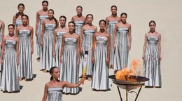 Na snímke grécka herečka Katerina Misichroniová, ktorá stvárňuje úlohu veľkňazky, zapaľuje olympijský oheň pre Olympijské hry mládeže v senegalskom Dakare na Panaténskom štadióne v Aténach.