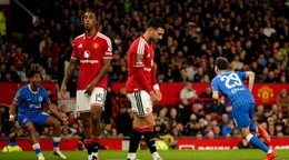 Vzadu Maxim De Cuyper oslavuje gól, vpredu sklamaní hráči Manchestru United.