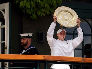 Češka Markéta Vondroušová prichádza na balkón s trofejou pre víťazku Wimbledonu.  