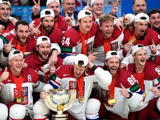 Českí hokejisti pózujú s trofejou po výhre na MS v hokeji 2024.