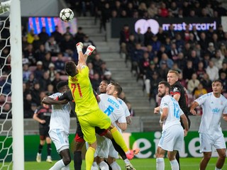 Brankár Dominik Takáč vyráža loptu, dole pod ním jeho spoluhráč Kevin Wimmer v zápase FC Midtjylland - ŠK Slovan Bratislava v play-off Ligy majstrov. 