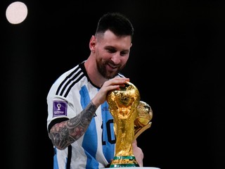 Lionel Messi sa dotýka trofeje pre víťazov MS vo futbale v Katare 2022.