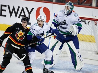 Zľava Martin Pospíšil, Noah Juulsen a brankár Kevin Lankinen v zápase NHL Vancouver Canucks - Calgary Flames.