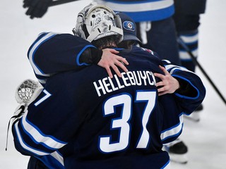 Brankári Winnipegu Eric Comrie (vľavo) a Connor Hellebuyck sa objímajú po výhre v rozhodujúcom siedmom zápase.