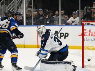 Brankár Connor Hellebuyck inkasuje po tom, čo sa presadil Nathan Walker v zápase St. Louis Blues - Winnipeg Jets v 6. dueli 1. kola play-off NHL.