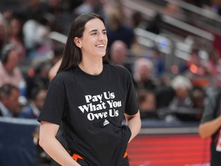 Caitlin Clarková v tričku „Zaplaťte nám, čo nám patrí“.