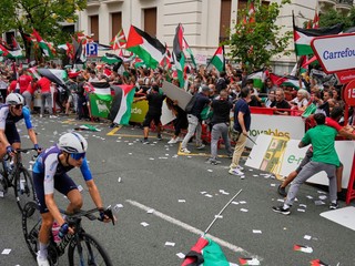 Ľudia držia palestínske vlajky počas toho, ako sa snažia narušiť etapu na Vuelte.