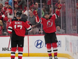 Slovenský hokejista v drese New Yorku Devils Šimon Nemec (vľavo) sa teší z gólu, ktorý strelil jeho spoluhráč Timo Meier (vpravo).