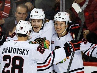 Hokejisti Chicago Blackhawks oslavujú gól v sieti Calgary Flames.